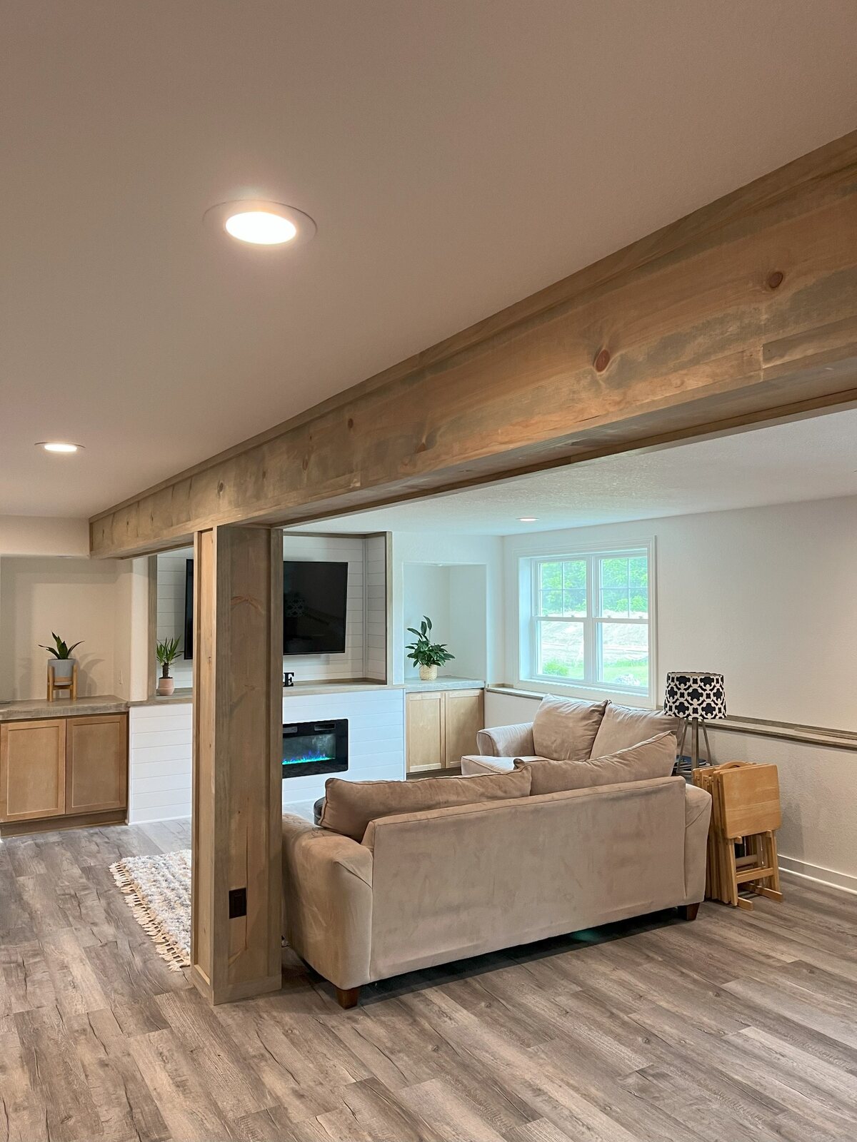 Finished basement living area with fireplace and built-in cabinetry